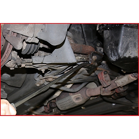 Blick von unten auf ein Auto. Der Auspuff und weitere Fahrzeugteile sind zu sehen.